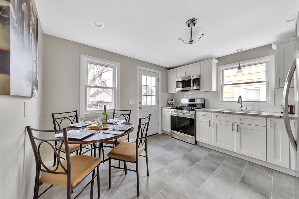 63 Haskin Street Springfield, MA 01109 - Photo 3 of 27 a kitchen with granite countertop a stove a sink a dining table and chairs