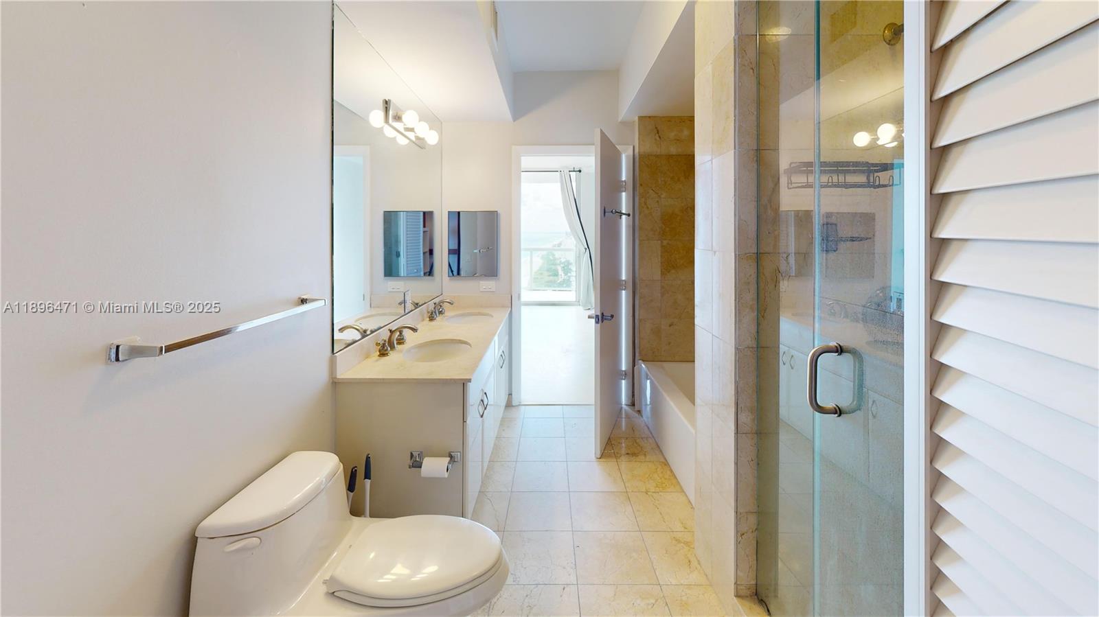 6365 Collins Avenue, Unit 2904 Miami Beach, FL 33141 - Photo 19 of 28 a bathroom with a granite countertop toilet sink and shower