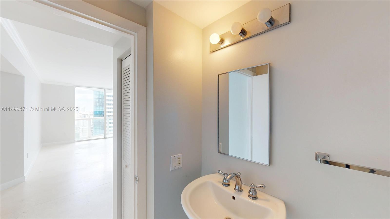 6365 Collins Avenue, Unit 2904 Miami Beach, FL 33141 - Photo 6 of 28 a bathroom with a sink and a mirror