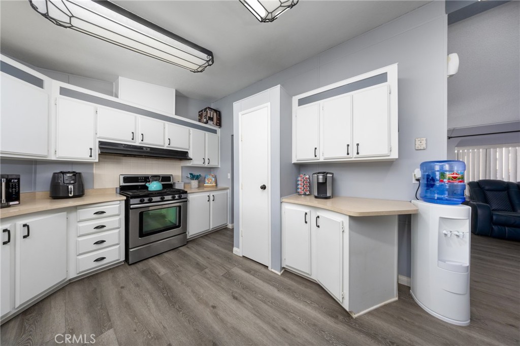 4080 Pedley Road, Unit 53 Jurupa Valley, CA 92509 - Photo 20 of 41 a kitchen with stainless steel appliances granite countertop a stove top oven a sink and white cabinets