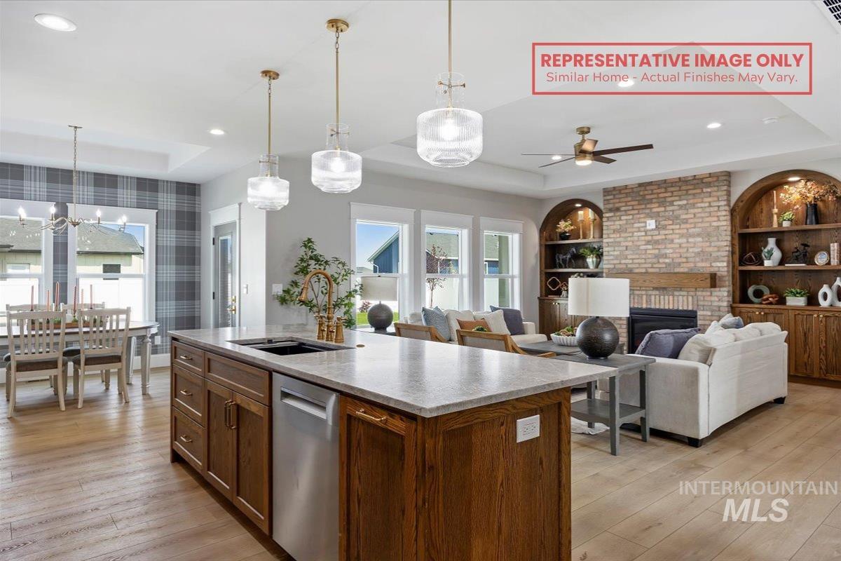 1513 Lavender Rupert, ID 83350 - Photo 16 of 16 Kitchen with a tray ceiling, open floor plan, an island with sink, dishwasher, and a ceiling fan