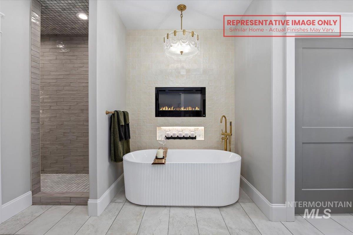1513 Lavender Rupert, ID 83350 - Photo 5 of 16 Bathroom with a freestanding bath, a tiled fireplace, recessed lighting, and tile walls