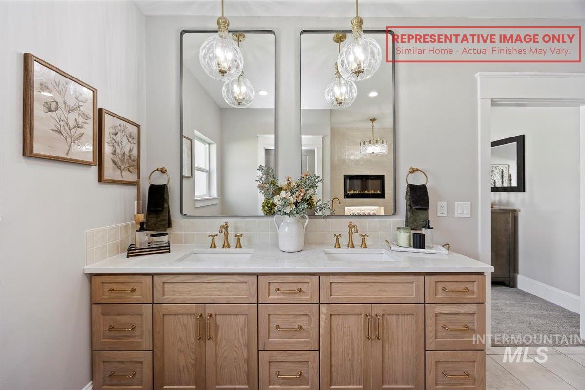 1513 Lavender Rupert, ID 83350 - Photo 6 of 16 Bathroom featuring double vanity, backsplash, hanging lights, and light tile patterned floors
