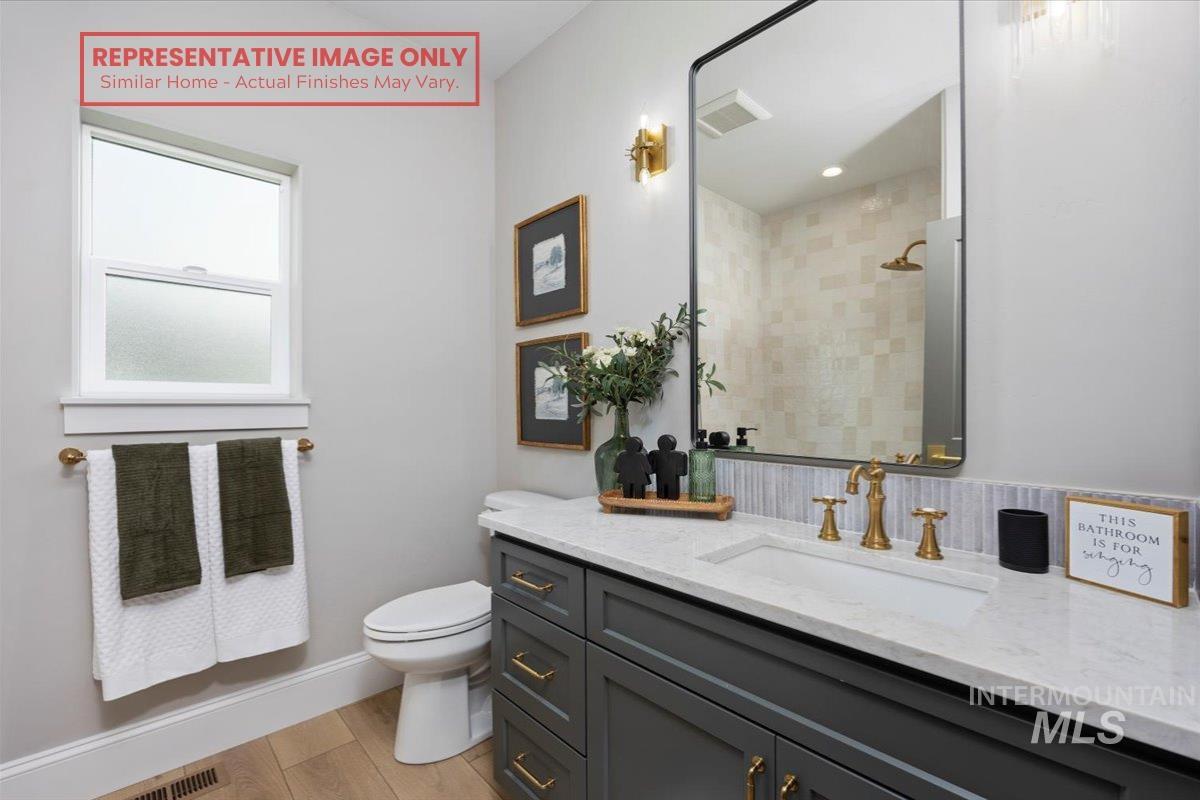 1513 Lavender Rupert, ID 83350 - Photo 8 of 16 Full bathroom with vanity, light wood finished floors, and a tile shower