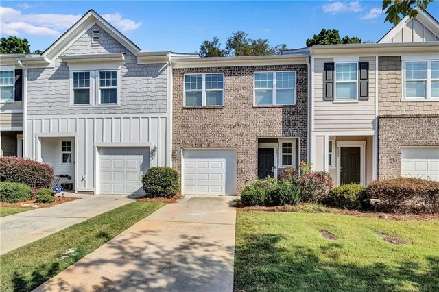 a front view of a house with a yard and potted plants