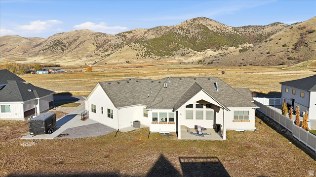 534 East Fish Hatchery Road Mantua, UT 84324 - Photo 67 of 87 Back of property featuring a patio, stucco siding, roof with shingles, a mountain view, and a fenced backyard
