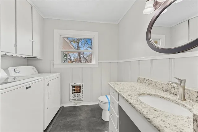 a bathroom with a granite countertop sink mirror vanity and toilet