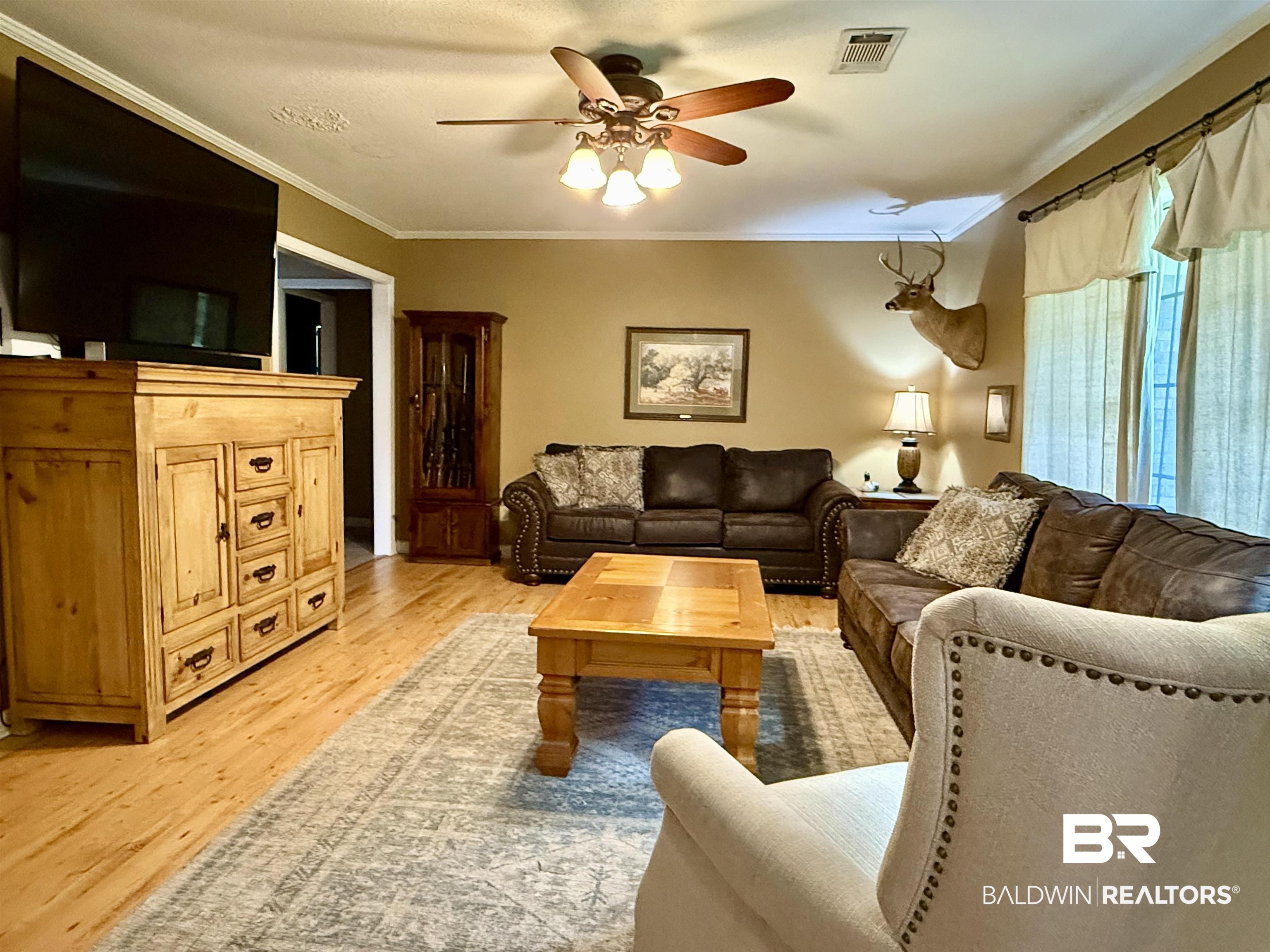 5971 Appleton Road Brewton, AL 36426 - Photo 3 of 23 Living room with a ceiling fan, crown molding, and light wood finished floors