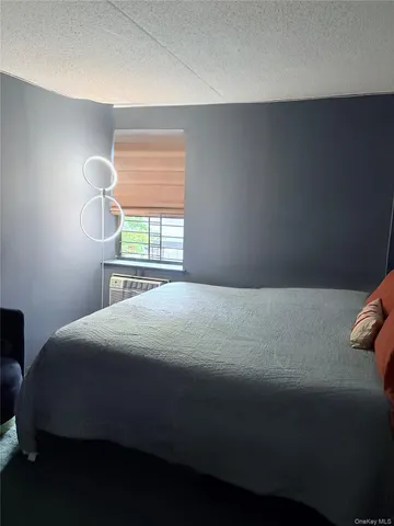 a bedroom with a bed next to a window