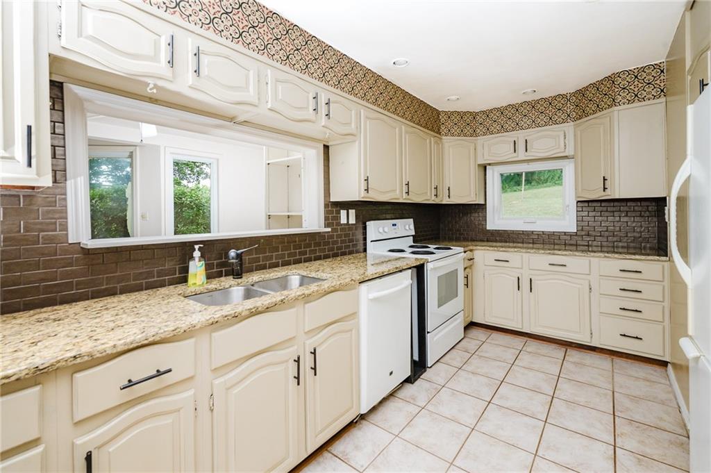 145 Hood School Road Indiana, PA 15701 - Photo 40 of 46 a kitchen with granite countertop white cabinets white appliances and a sink