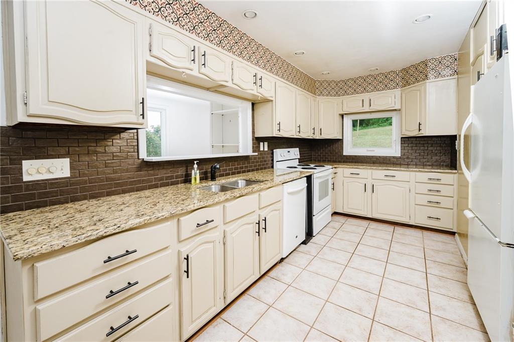 145 Hood School Road Indiana, PA 15701 - Photo 42 of 46 a kitchen with granite countertop white cabinets white appliances with a sink and dishwasher
