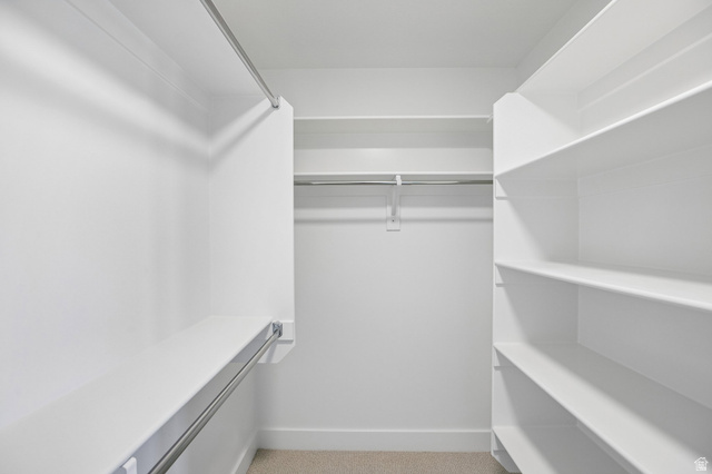 11781 South Halls Crk Road Draper, UT 84020 - Photo 22 of 33 Walk-in closet featuring white built-in shelving, multiple hanging rods, and carpet flooring