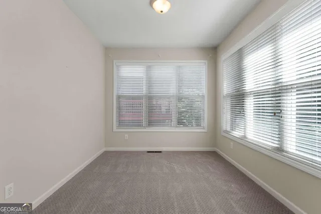 an empty room with a window and a ceiling fan