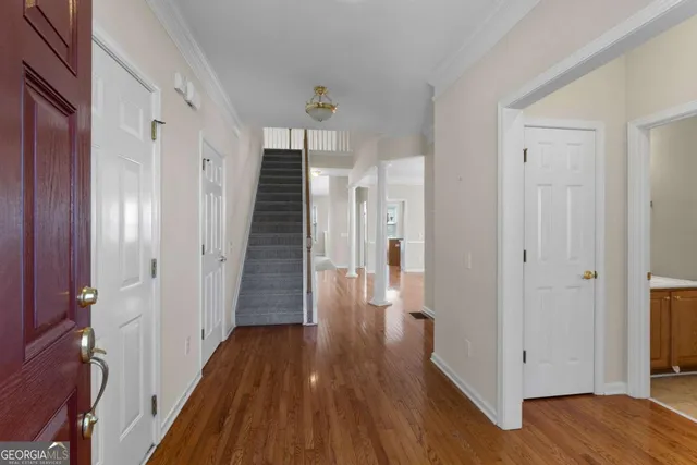 a view of a hallway with wooden floor and staircase