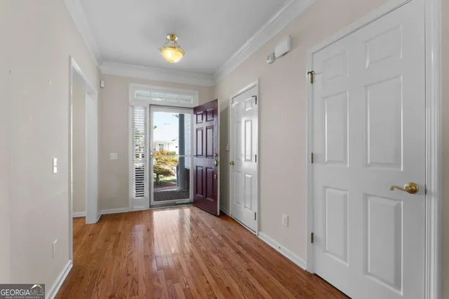 a view of a hallway with wooden floor and closet area