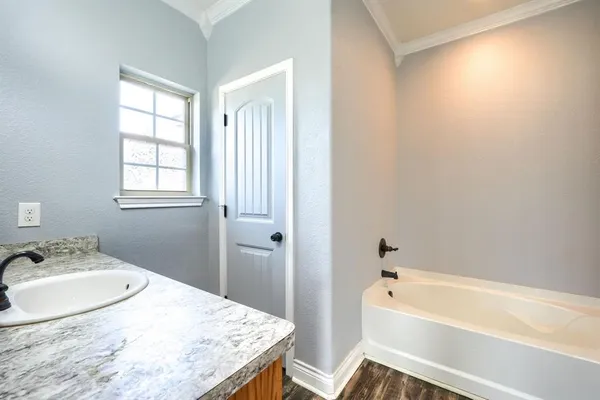 a bathroom with a granite countertop sink a mirror and a bathtub