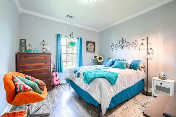 a bedroom with bed and wooden floor