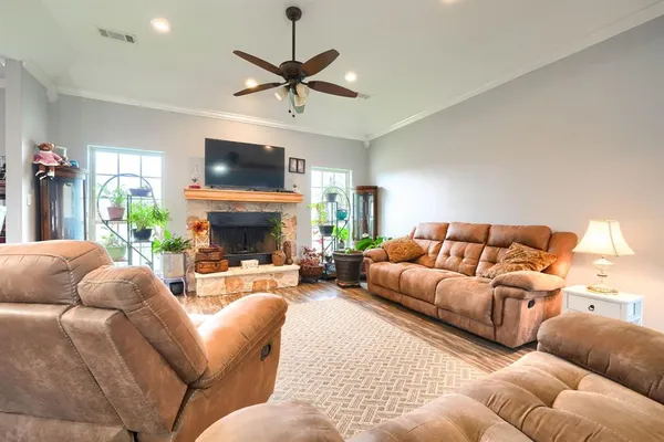 a living room with furniture a flat screen tv and a fireplace