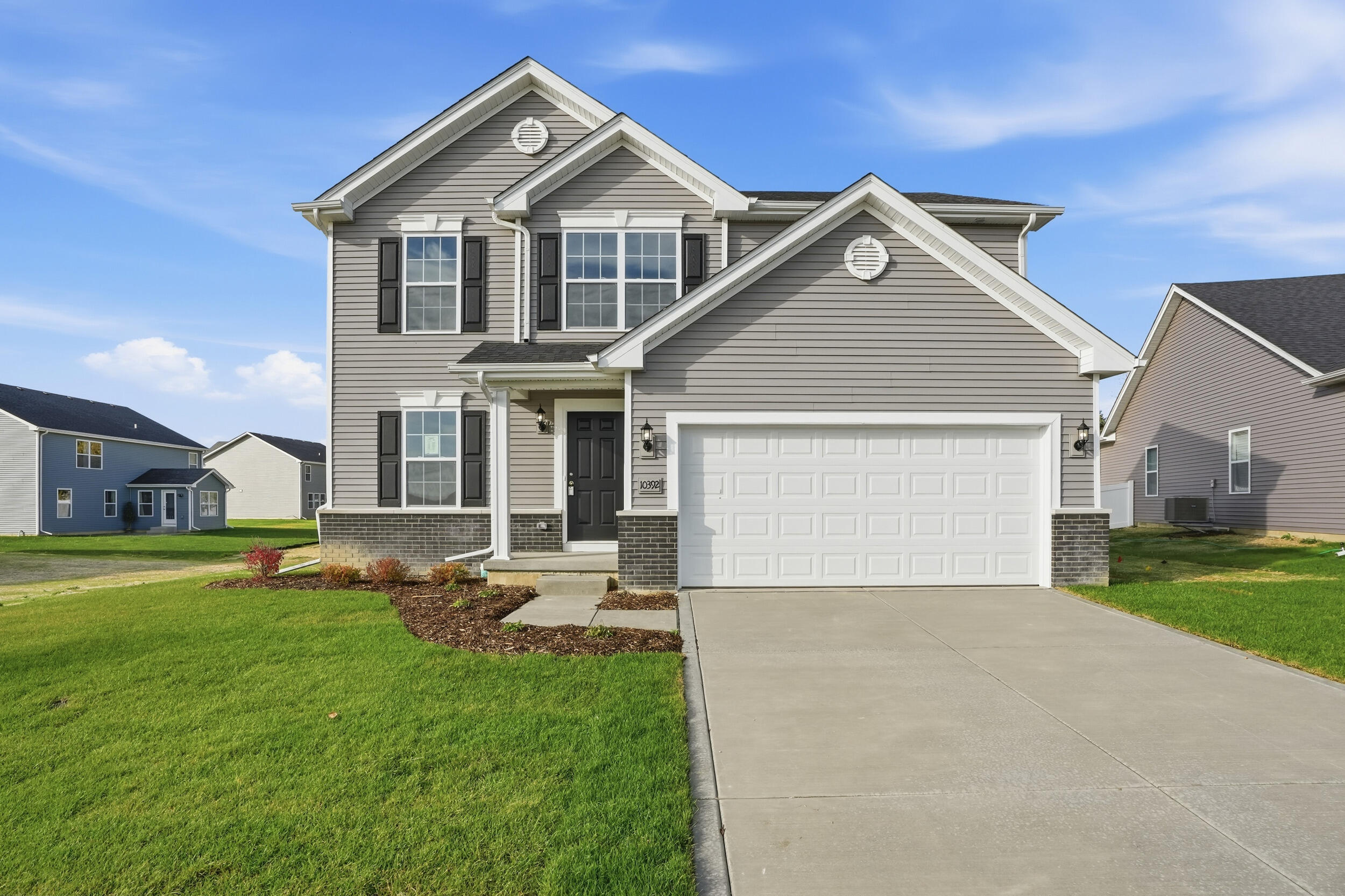 a front view of a house with a yard and garage