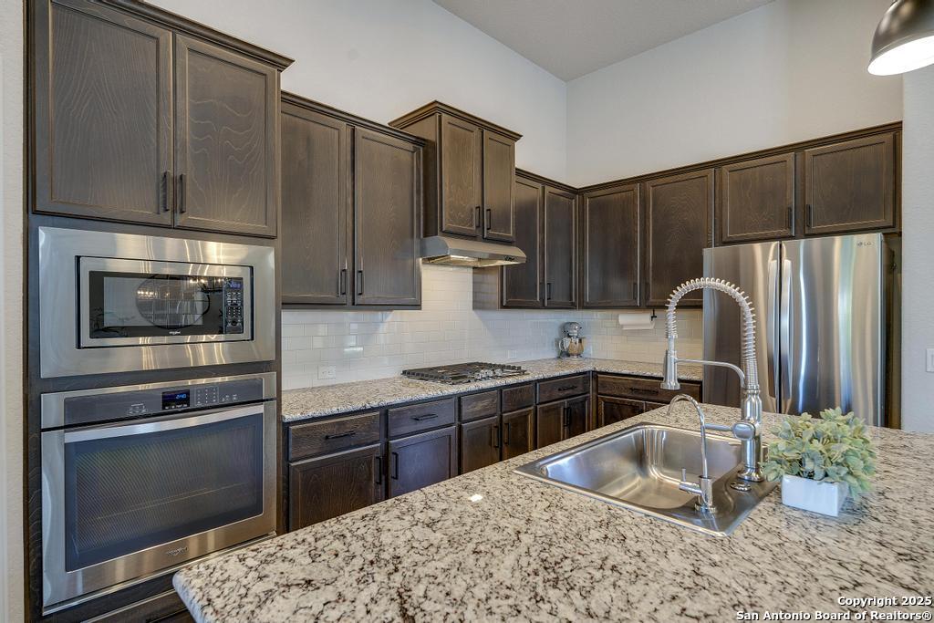 12805 Big Tank Ranch San Antonio, TX 78245 - Photo 11 of 35 a kitchen with stainless steel appliances granite countertop a sink stove and refrigerator
