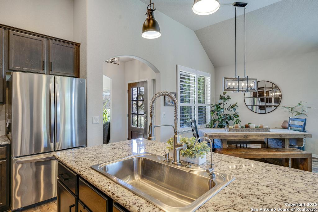12805 Big Tank Ranch San Antonio, TX 78245 - Photo 12 of 35 a kitchen with stainless steel appliances granite countertop a sink dishwasher a refrigerator and a stove with wooden floor