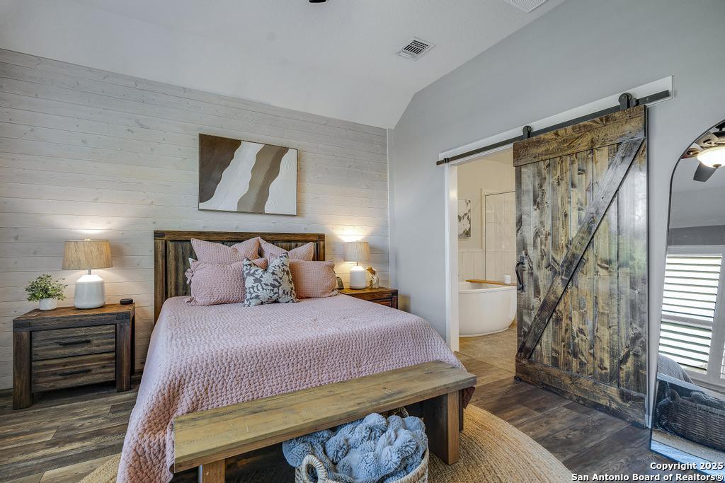 12805 Big Tank Ranch San Antonio, TX 78245 - Photo 18 of 35 a bedroom with a bed a mirror and a window