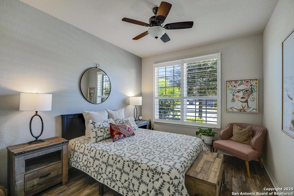 12805 Big Tank Ranch San Antonio, TX 78245 - Photo 23 of 35 a bedroom with a bed large window and a chandelier
