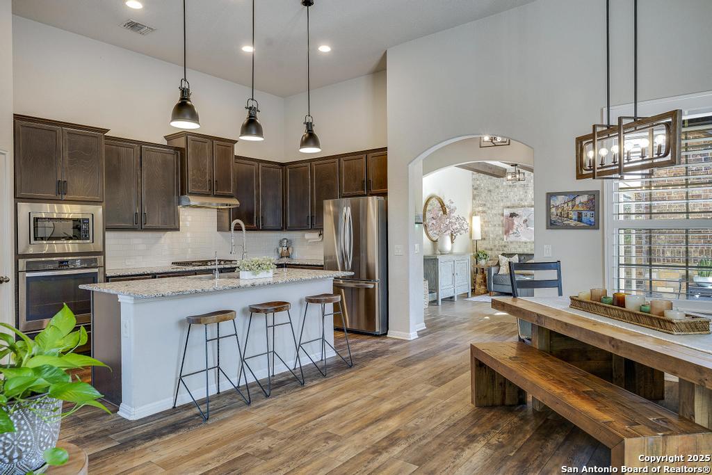 12805 Big Tank Ranch San Antonio, TX 78245 - Photo 9 of 35 a kitchen with kitchen island a large counter top space a sink stainless steel appliances and cabinets