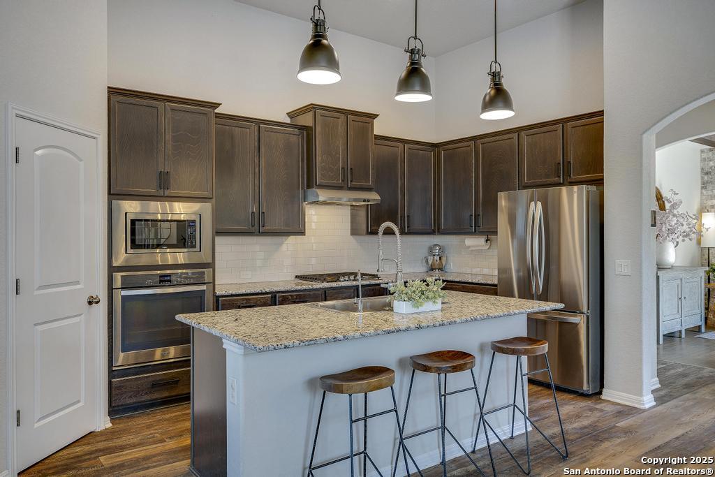 12805 Big Tank Ranch San Antonio, TX 78245 - Photo 10 of 35 a kitchen with granite countertop a refrigerator stove and microwave
