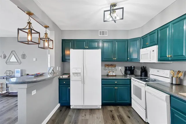 a kitchen with a sink a refrigerator and cabinets