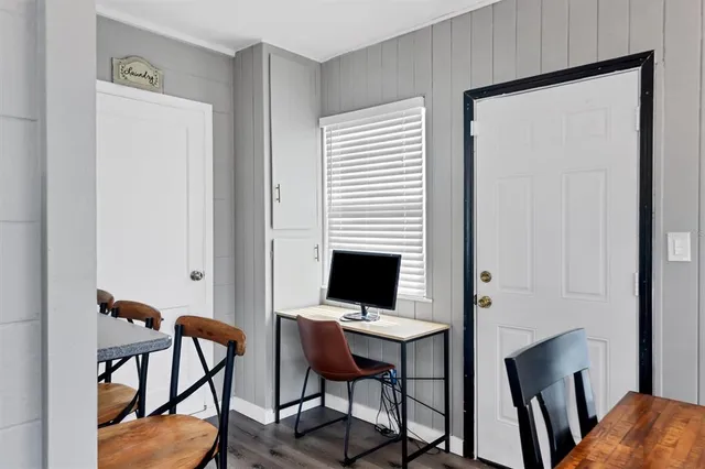 a view of a workspace with furniture and wooden floor
