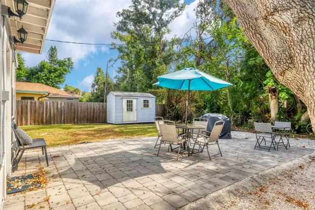 a view of a patio with a table and chairs under an umbrella