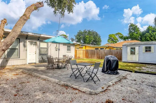 a view of a house with backyard and sitting area