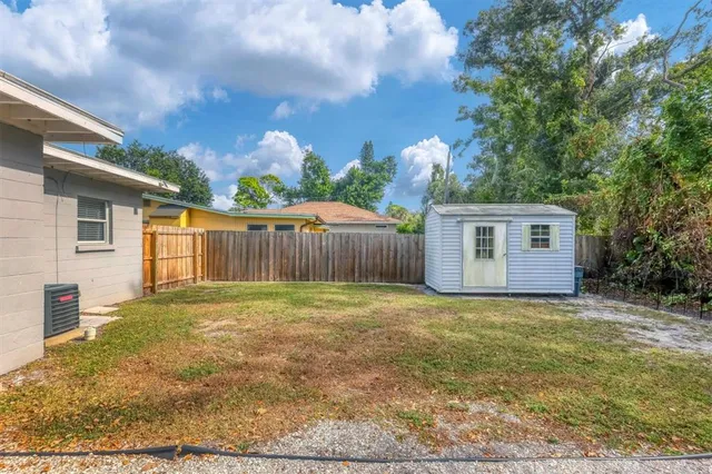 a view of a yard in front of a house with large tree