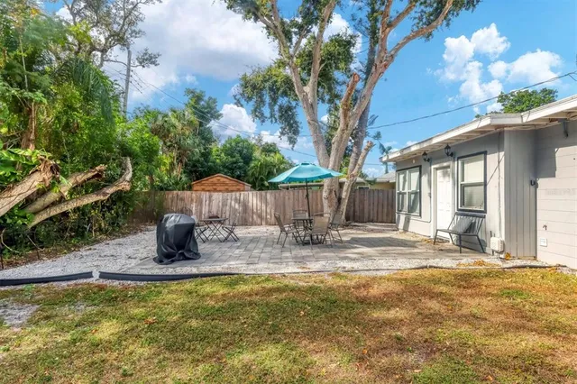 a view of a house with backyard and sitting area