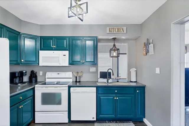 a kitchen with kitchen island granite countertop a sink cabinets and stainless steel appliances