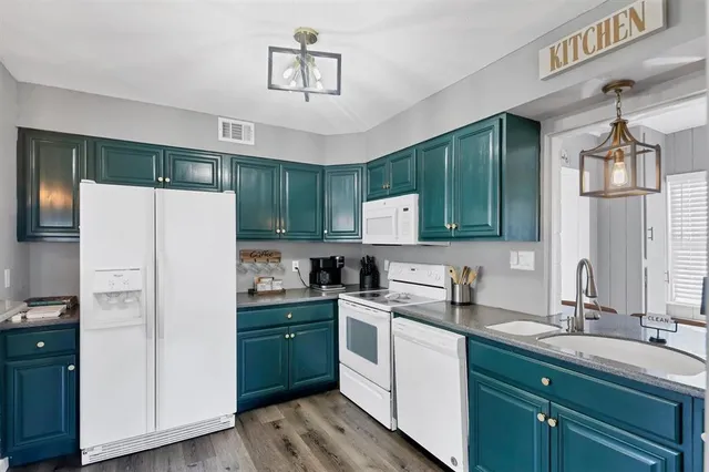 a kitchen with a sink a refrigerator and cabinets