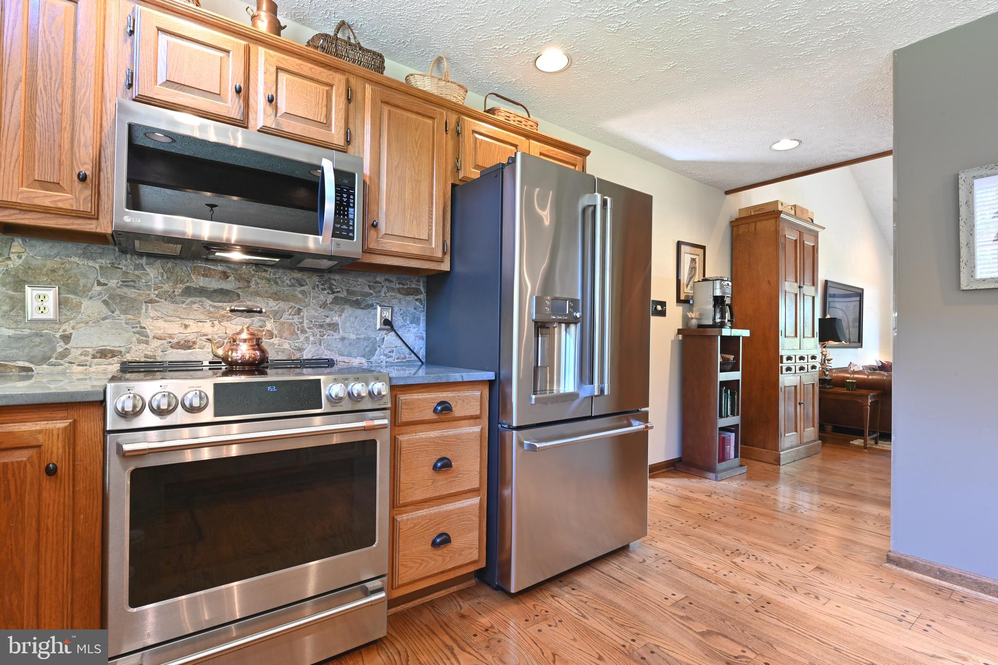 2520 Colonial Road Accokeek, MD 20607 - Photo 13 of 74 a kitchen with stainless steel appliances granite countertop a stove microwave and refrigerator