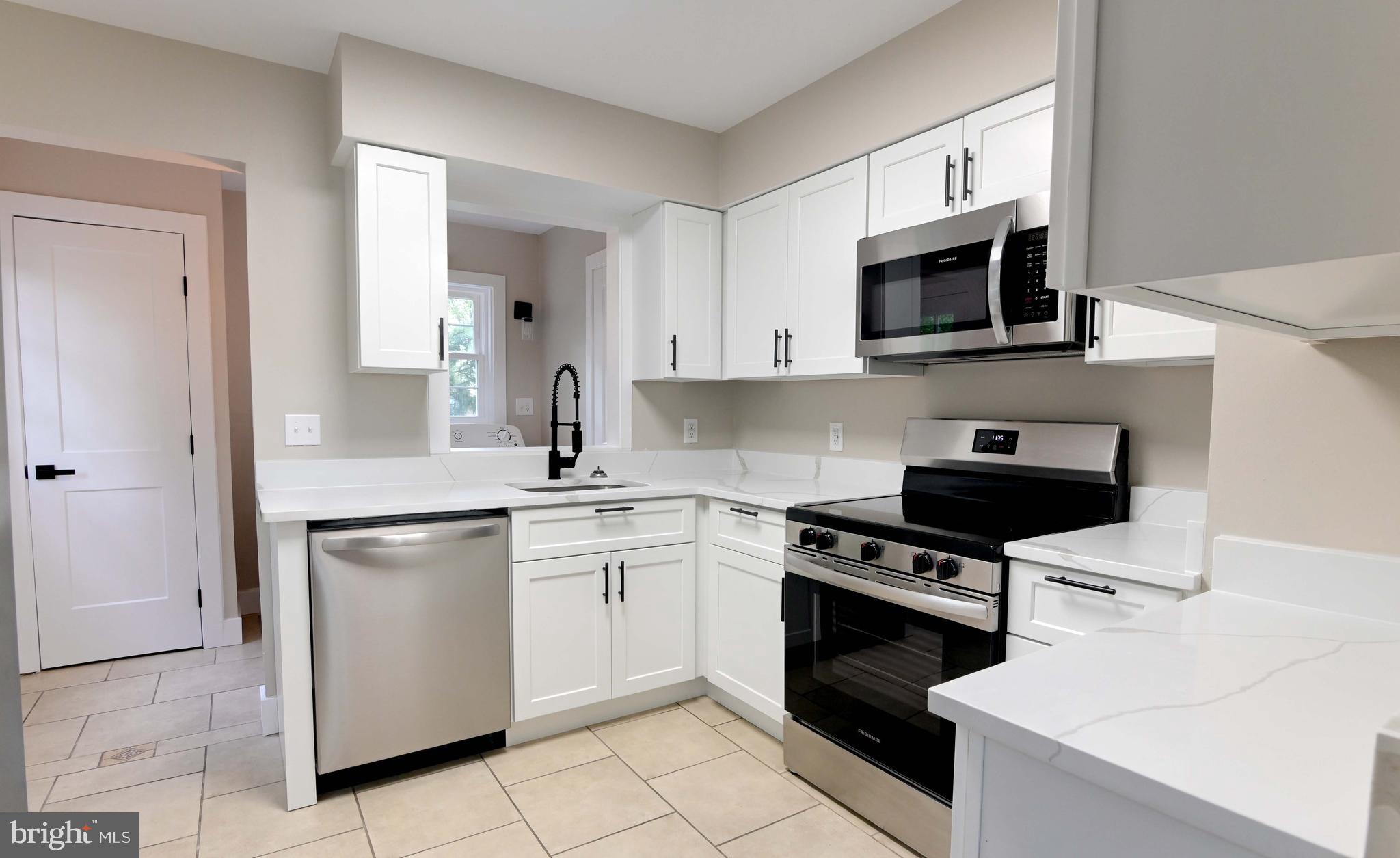1616 Beech Road St. Leonard, MD 20685 - Photo 19 of 40 a kitchen with stainless steel appliances granite countertop white cabinets a stove a sink and dishwasher