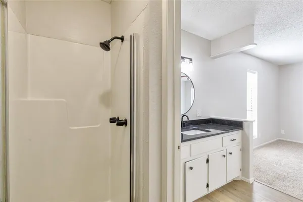 a bathroom with a granite countertop sink and a mirror