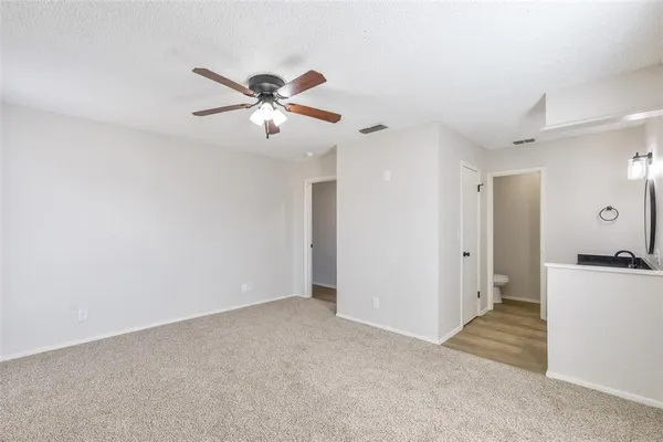 a view of a room with a ceiling fan and a window