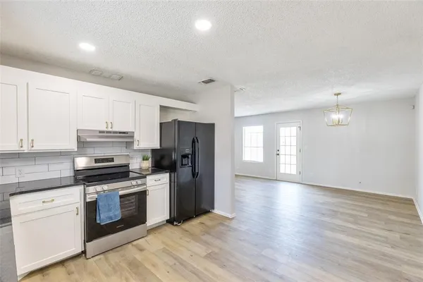 a kitchen with a refrigerator stove and wooden cabinets