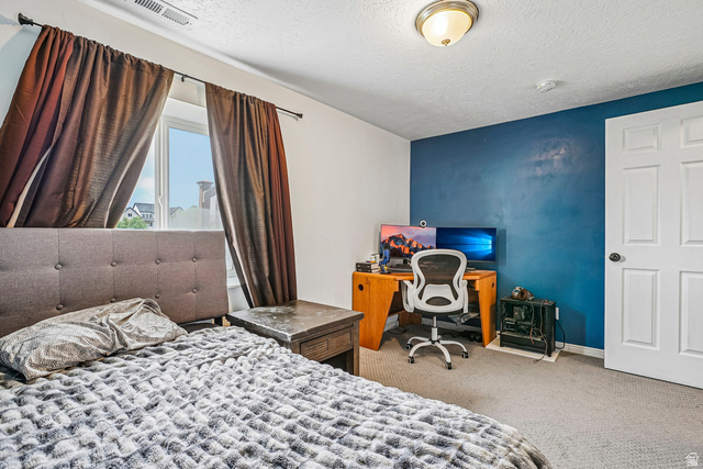 203 North 1900th Street West Mapleton, UT 84664 - Photo 33 of 48 Bedroom featuring a window, textured carpet flooring, and a blue accent wall