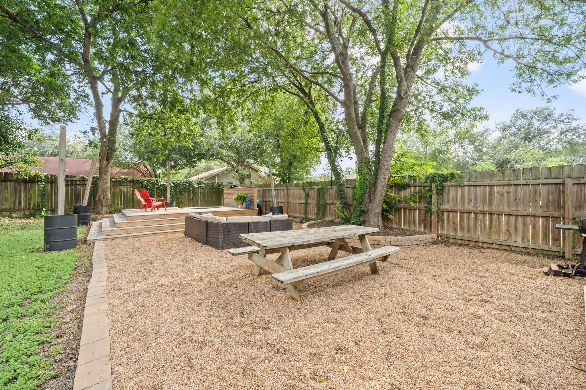 705 Dulwich Street Austin, TX 78748 - Photo 26 of 36 A private backyard retreat features a wooden deck and a spacious gravel area, perfect for gatherings.