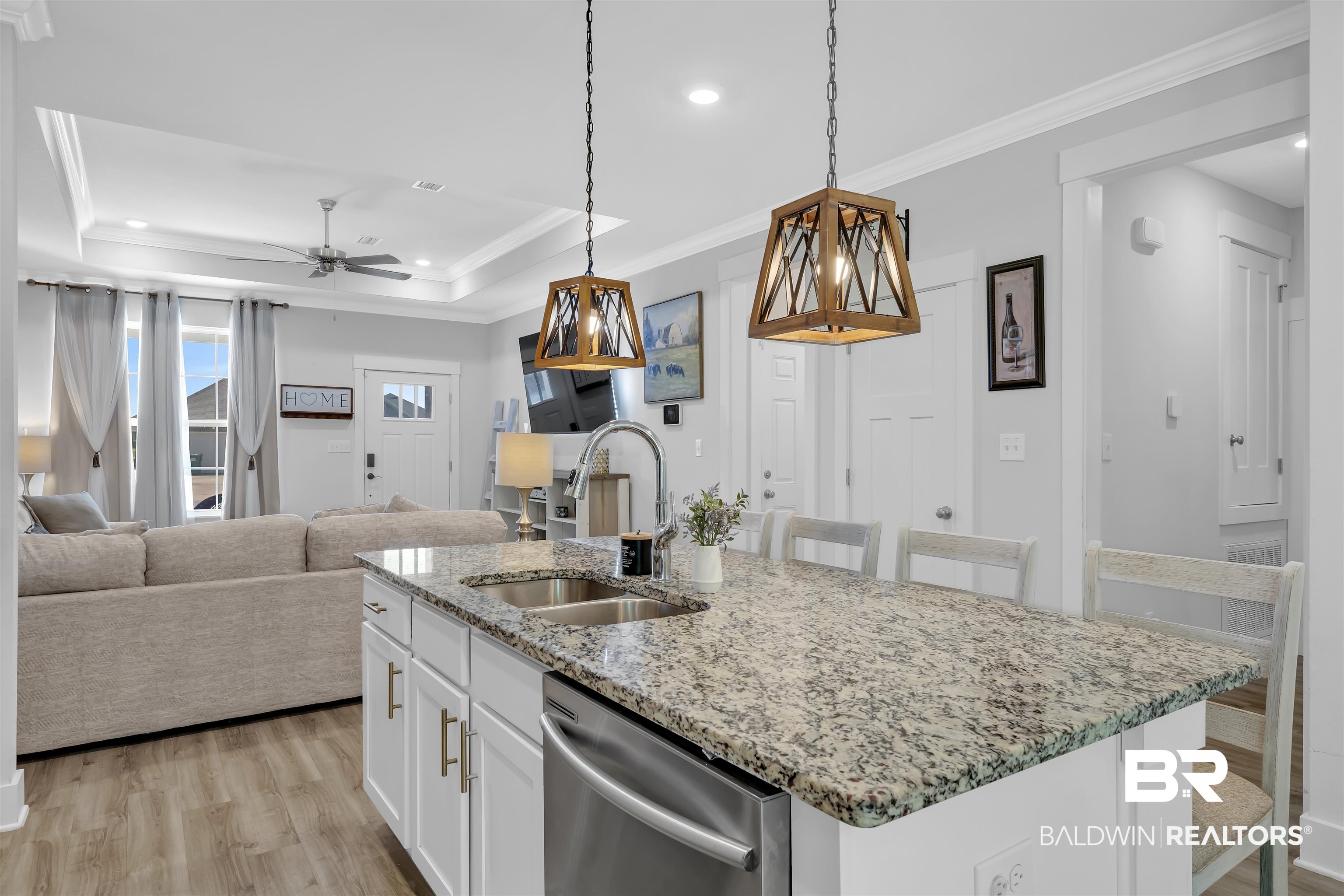 16504 Prado Loop Loxley, AL 36551 - Photo 12 of 45 Kitchen featuring white cabinetry, light stone countertops, a breakfast bar, stainless steel dishwasher, and a center island with sink