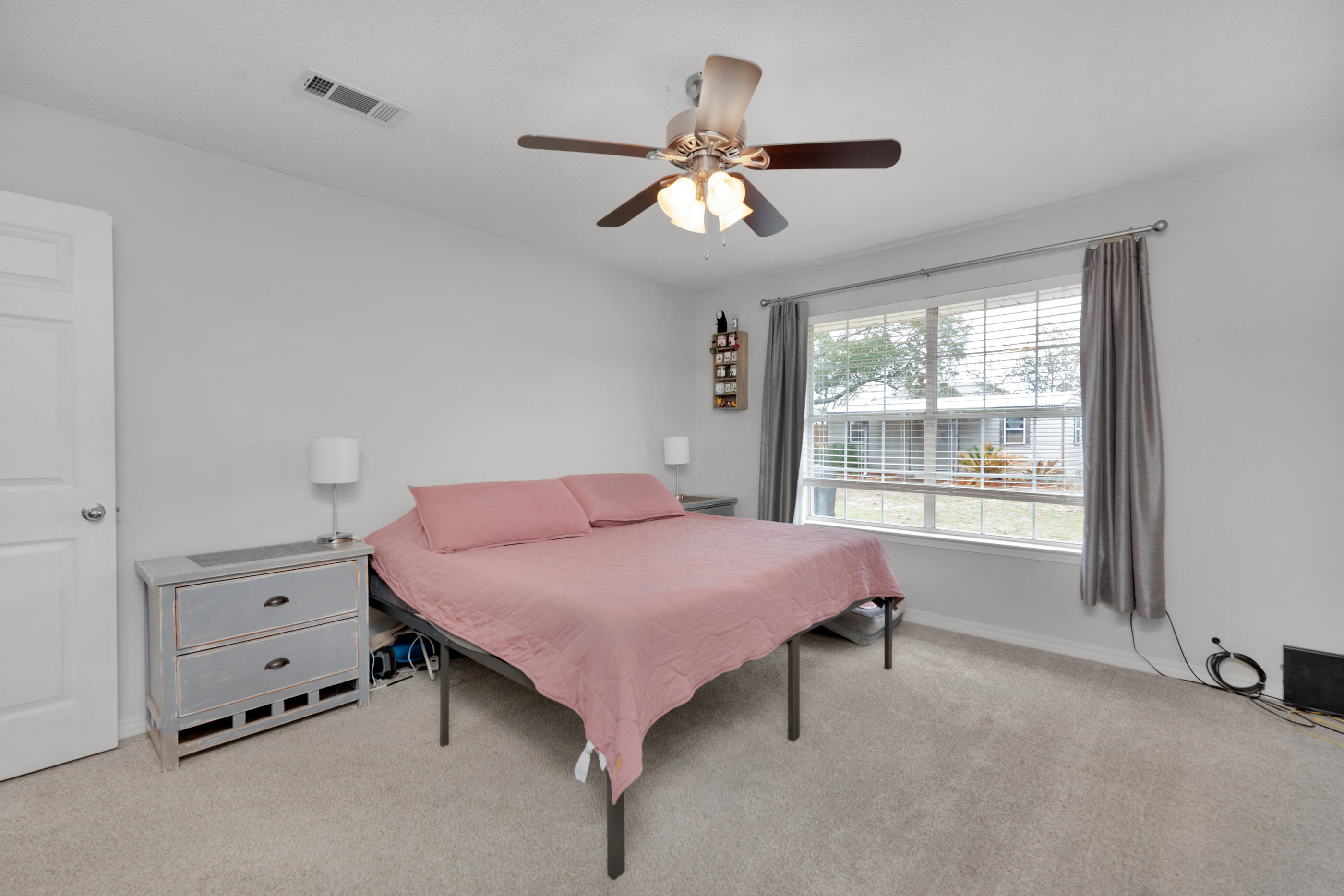 2831 Atoka Trail Crestview, FL 32539 - Photo 14 of 27 a bedroom with a bed and a chandelier