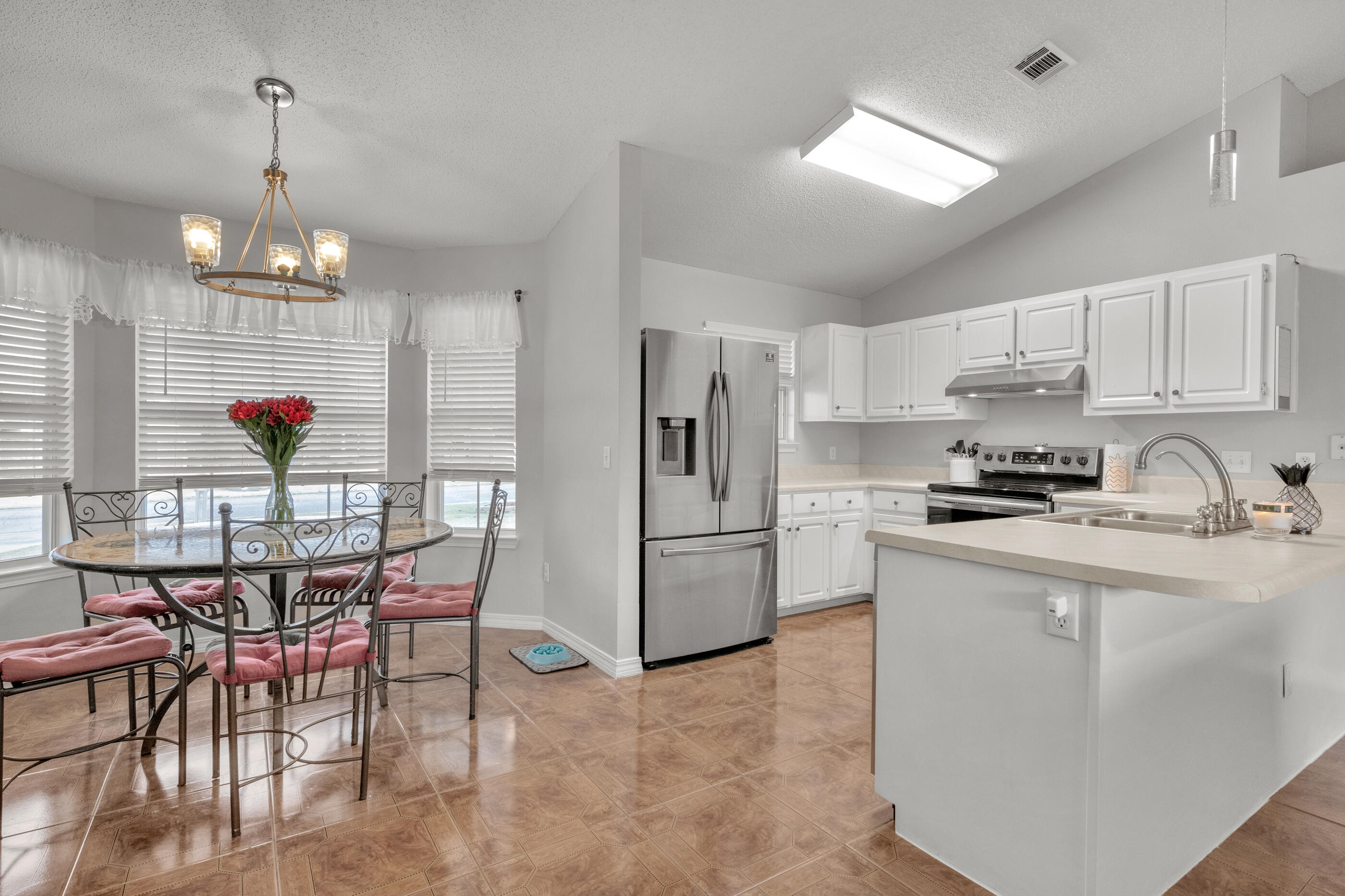 2831 Atoka Trail Crestview, FL 32539 - Photo 7 of 27 a kitchen with stainless steel appliances granite countertop a dining table chairs refrigerator and cabinets