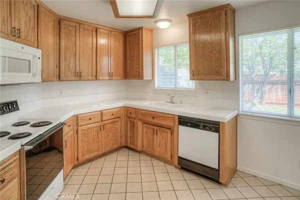 a kitchen with granite countertop a sink stove and cabinets