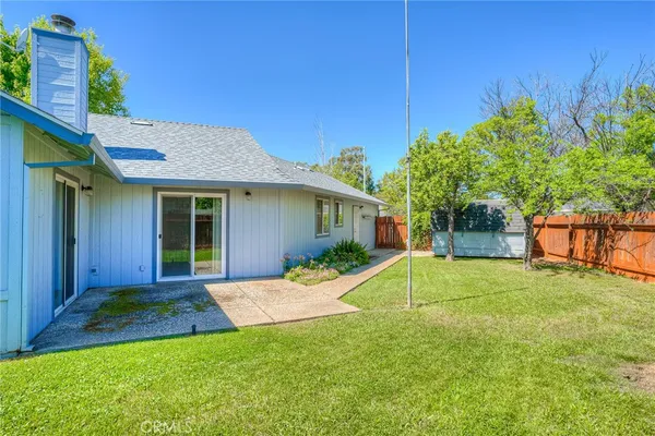 a view of a house with a backyard and a tree