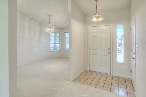 an empty room with windows and chandelier